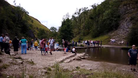 Timelapse-of-Dovedale-Stepping-Stones-in-Derbyshire,-Peak-District,-England,-UK-showing-crowds-of-tourists-crossing-the-stepping-stones-over-the-river-Dove