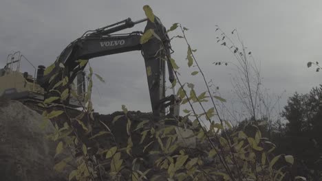 Smooth-follow-shot-of-excavator-arm-digging-in-mud-and-gravel,-Flat-Log-footage
