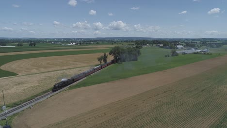 Aerial-View-of-Farmlands-and-Countryside-with-a-Vintage-Steam-Train-Puffing-Along-on-a-Sunny-Summer-Day