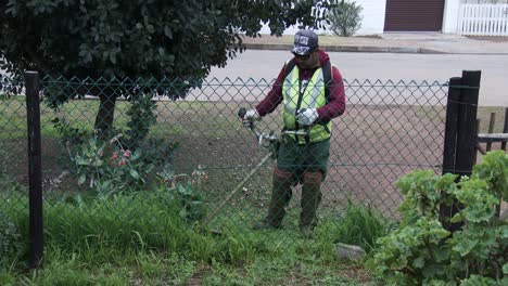 A-garden-services-man-using-a-weed-eater-in-a-rural-town