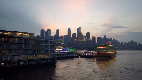 Tourist-sightseeing-ship-cruising-on-the-confluence-of-Yangtze-and-Jialing-rivers-in-Chongqing-town-at-dusk