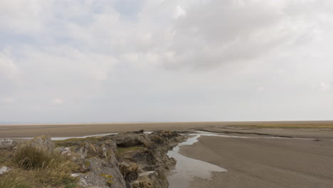 Time-lapse-of-a-section-of-coastline-when-the-tide-is-out,-clouds-moving