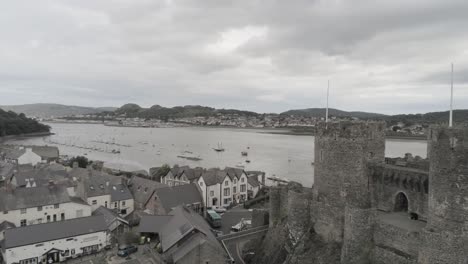 Medieval-landmark-historic-Conwy-castle-aerial-view-above-Welsh-seaside-landscape-slow-right-pan
