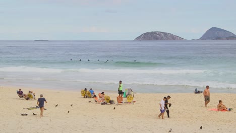 Gente-Pasando-El-Rato-En-La-Playa-De-Ipanema,-Bahía-De-Guanabara,-Río-De-Janeiro,-Brasil