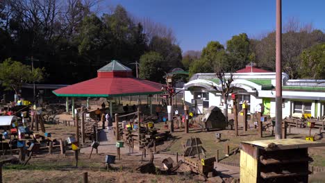 People-Enjoying-The-View-At-The-Machida-Squirrel-Park-In-Japan-With-Colorful-Houses-For-Adorable-Squirrels-On-A-Bright-Sunny-Weather---Wide-Shot