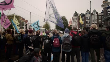 Menschen-Protestieren-Gegen-Einen-Klimastreik-Der-Extinction-Rebellion-In-Amsterdam,-Gesehen-Von-Der-Polizeiblockade