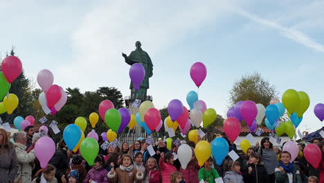 Group-of-children-and-balloons-at-San-Carlone-statue,-Arona,-Italy