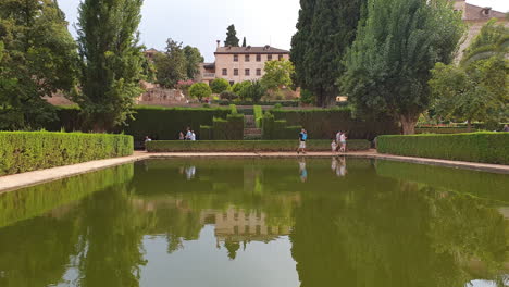 Tourists-visit-pond-Portico-Palace,Alhambra,Spain,Granada.Zoom-out-shot