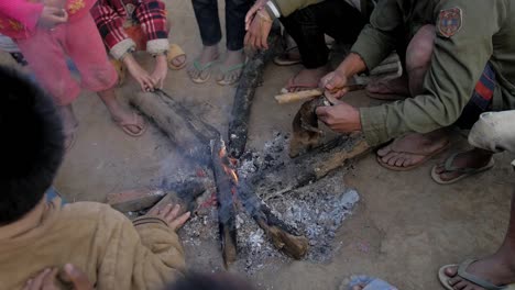 Laos-village-community-cooking-Loris-animal-over-flaming-bonfire-in-rural-scene