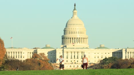 Front-view-of-Capitol-building-and-couple-of-tourists-playing-baseball-on-lawn