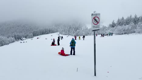 Trineo-De-Personas-En-La-Pista-De-Esquí-Con-Señal-De-Prohibido-En-Frente