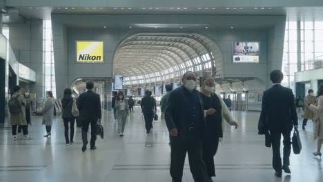 Gehende-Passagiere-Mit-Gesichtsmasken-Am-Bahnhof-Shinagawa-In-Tokio-–-Schutzmaßnahmen-Gegen-Covid-19-–-Weitwinkelaufnahme,-Zeitlupe
