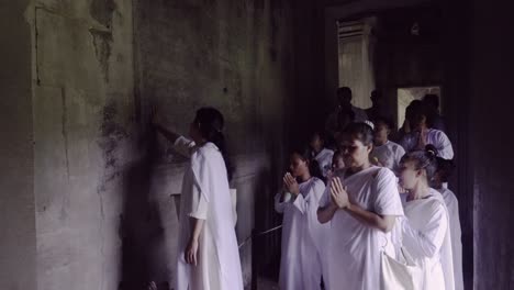 Ley-men-and-women-in-white-robes-preying-on-their-annual-buddhist-pilgrimage-during-covid-19-to-Angkor-Wat,-Cambodia