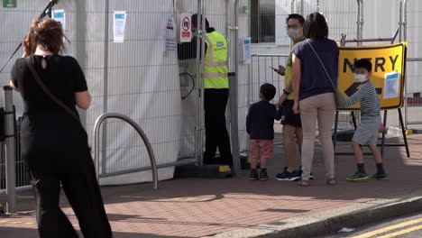 A-family-is-directed-into-the-entrance-of-an-appointment-only-Covid-19-testing-centre-by-Serco-security-staff