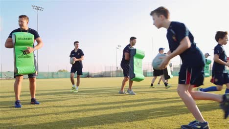 Young-Rugby-Players-At-The-Field-During-Workout-Training-With-Their-Coaches---low-angle-full-shot