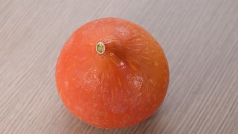 Orangefarbener-Kürbis,-Der-Auf-Holzhintergrund-Rotiert