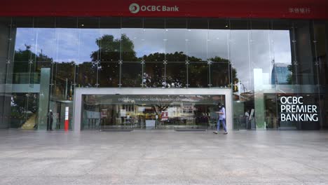 Woman-walking-outside-Ocbc-Centre,-bank-headquarters,-Chulia-Street,-downtown-core,-Singapore