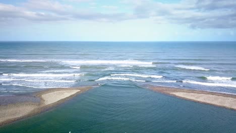 Stunning-aerial-where-the-Mokihinui-River-Mouth-meets-the-Tasman-Sea-in-New-Zealand---Aerial-Dolly-in-shot