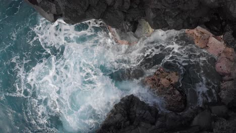 Aqua-blue-ocean-water-circulates-around-in-lava-rock-coves-along-the-grey-coast-of-Hawaii