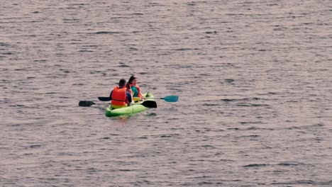 A-couple-is-resting-on-a-kayak-in-calm-waters