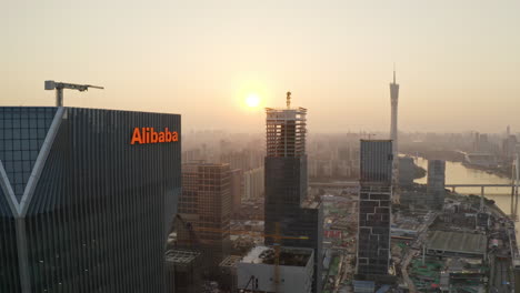 Naher-Vorbeiflug-In-Der-Nähe-Des-Bürogebäudes-Der-Alibaba-Gruppe-Mit-Der-Enthüllung-Des-Canton-Tower-Und-Des-CBD-Bereichs-Im-Stadtzentrum-Im-Hintergrund-Bei-Wunderschönem-Goldenen-Sonnenuntergang