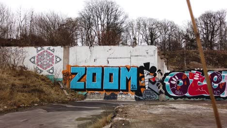 Graffiti-wall-art-in-old-paper-mill-ruins-in-Vargön,-Sweden,-wide-shot