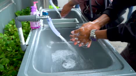 People-wash-hands-before-work-as-a-mean-to-prevent-Covid-19-outbreak,-close-up