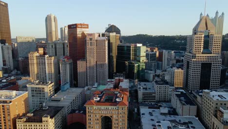 Aerial-view-of-downtown-Pittsburgh,-USA,-during-sunset---tracking,-drone-shot
