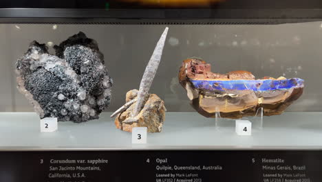 Tucson-Gem-Show-–-Quarz-,-Hämatit-,-Korund--Und-Opalmineralien-In-Einer-Glasvitrine