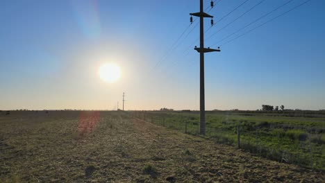 Rückwärtsantenne-Von-Stromleitungen,-Autos-Und-Feldern-In-La-Pampa,-Argentinien