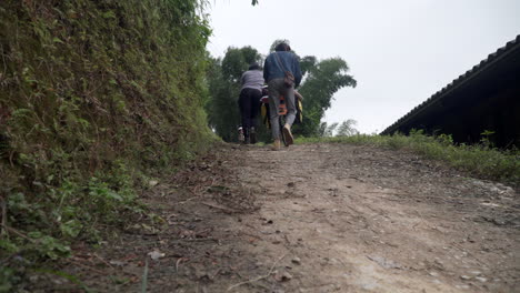 two-cyclists-pushing-a-bicycle-uphill-in-the-mountains