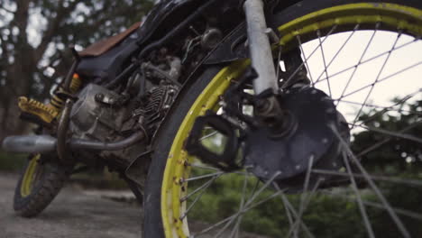Close-up-of-wheels,-rusty-abandoned-bike-in-rural-outdoors
