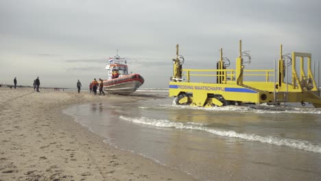 Gelber-Traktor-Verlässt-Den-Strand,-Nachdem-Er-Das-KnRM-Rettungsboot-Am-Ufer-Der-Nordsee-In-Katwijk,-Zuid-Holland,-Niederlande,-Zu-Wasser-Gelassen-Hat