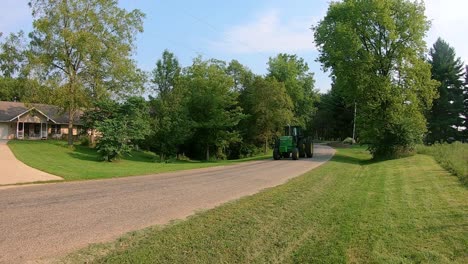 Two-John-Deere-tractors-from-Antique-Engine-and-Tractor-Association,-one-tractor-has-a-post-hole-differ-attached