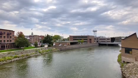 Drohnenflug-über-Rock-River-In-Richtung-Innenstadtgebäude-In-Beloit,-Wisconsin-An-Einem-Bewölkten-Tag