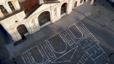 Aerial-pan-of-of-Córdoba-Cathedral-and-painting-on-ground,-Argentina