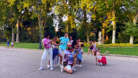 Grupo-De-Personas-Internacionales-Y-Colectivo-Lgtb-Bailando-El-Final-De-Una-Coreografía-En-El-Parque-Del-Retiro-En-Madrid,-España