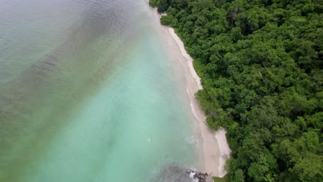 Turquoise-white-sand-beach-surrounded-by-jungle