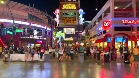 Fremont-Street-Erlebnis-In-Der-Innenstadt-Von-Las-Vegas-Mit-Vielen-Verschiedenen-Lichtern-Und-Farben-Mit-Touristen,-Die-über-Die-Straße-Gehen-Und-Während-Der-Covid-19-Pandemie-Mit-Masken-Reisen