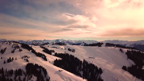 Schneebedeckte-Berge-In-Tiefen-Wolken-Und-Blauer-Himmel-Bei-Sonnenuntergang-Im-Winter