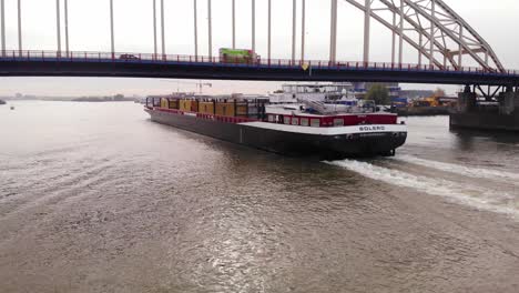 Aerial-View-Of-Bolero-Cargo-Ship-Passing-Under-Bridge-Over-The-Noord-In-Hendrik-Ido-Ambacht