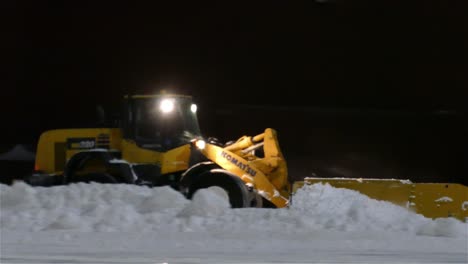 Wheel-loader-is-removing-snow-at-night-during-snowfall
