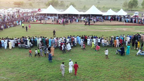 Public-cultural-event-with-tents-for-shade-and-a-crowd-waiting-for-the-show---sliding-aerial-view