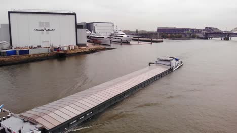 Aerial-View-Of-Lorca-Cargo-Ship-Going-Past-Oceanco-Shipyard-In-Ridderkerk-On-The-Noord