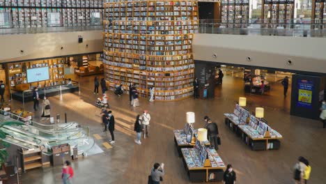 Menschen-Kaufen-Bücher-Und-Suchen-Nach-Informationen-In-Der-Starfield-Bibliothek-–-Draufsicht,-Schwenkzeitraffer