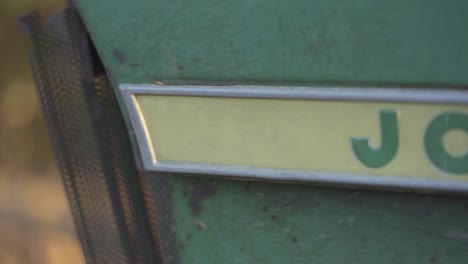 Macro-Shot-Of-A-John-Deere-Logo-On-A-Vintage-Tractor,-Farm-Machinery-For-Cultivating