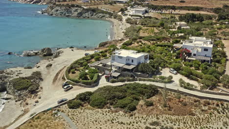 Paros-Greece-Aerial-v5-birds-eye-view-drone-fly-around-capturing-sparse-coastal-homes-and-secluded-paralia-lolantonis-beach-with-beautiful-aegean-sea-and-hilly-background---September-2021
