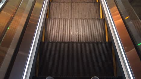 Füße-Die-Sich-Bewegende-Rolltreppe-Hinunter,-Erhöhte-Ansicht