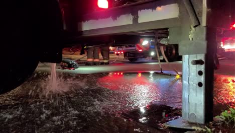 Wasser-Fließt-Aus-Einem-Geparkten-Feuerwehrauto-In-Toronto,-Kanada,-Umgeben-Von-Krankenwagen-Und-Feuerwehrleuten