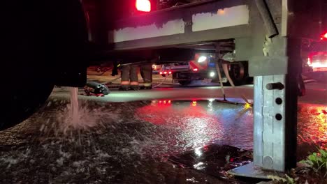 Agua-Que-Fluye-De-Un-Camión-De-Bomberos-Estacionado-En-Toronto,-Canadá,-Rodeado-De-Ambulancias-Y-Bomberos